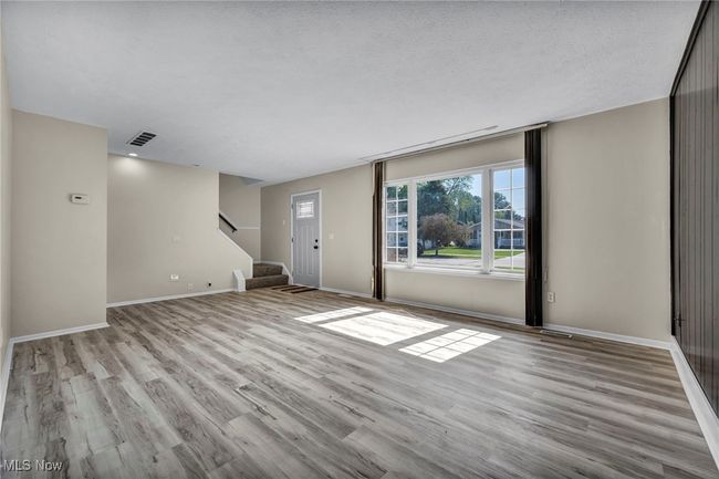 Unfurnished living room with stairs and wood finished floors | Image 28