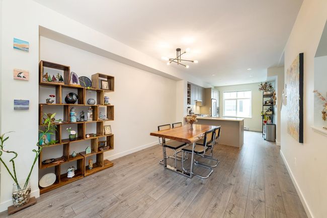 Dining room featuring light wood-style flooring, a chandelier, and baseboards | Image 6