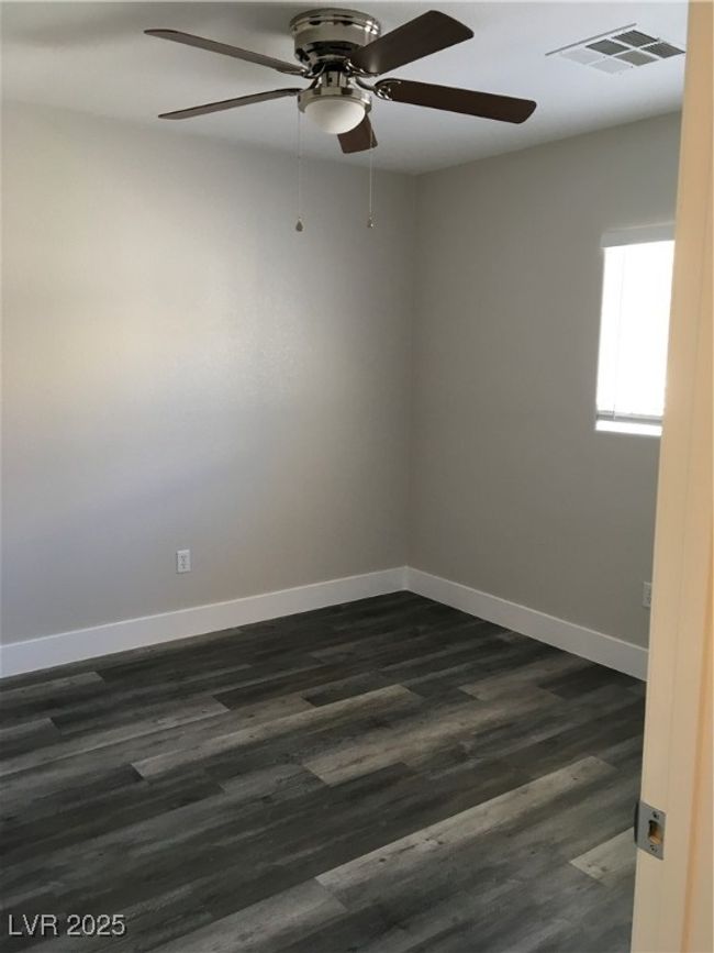 Unfurnished room featuring baseboards, visible vents, ceiling fan, and dark wood finished floors | Image 18