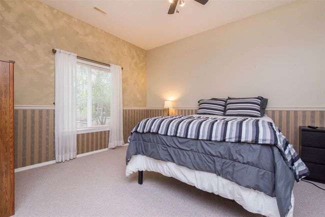 Bedroom featuring visible vents, carpet, baseboards, wallpapered walls, and a ceiling fan | Image 4