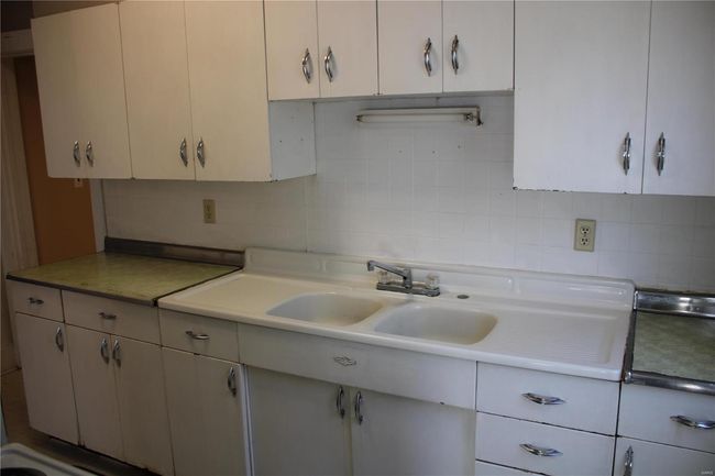 Kitchen with tasteful backsplash, light countertops, and a sink | Image 10