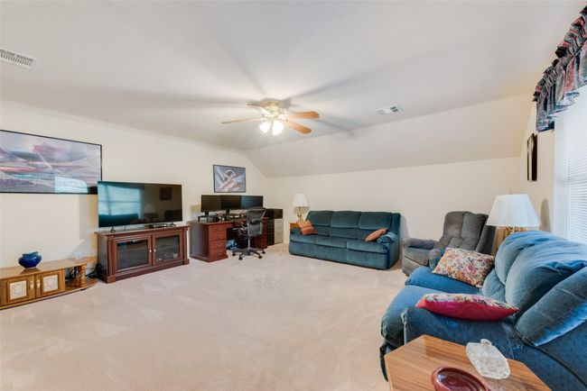 Living room with carpet floors, ceiling fan, an office area, and vaulted ceiling | Image 31