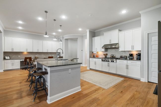 The home chef will fall in love with this gourmet kitchen, adorned with recessed and pendant lighting, stainless steel appliances, granite counters and pantry. | Image 14