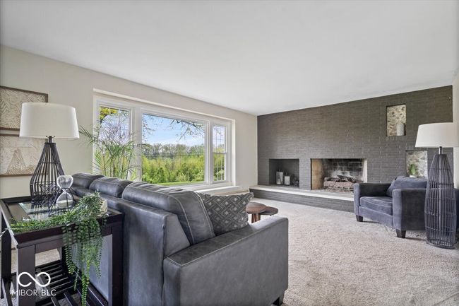living area featuring carpet and a large fireplace | Image 8