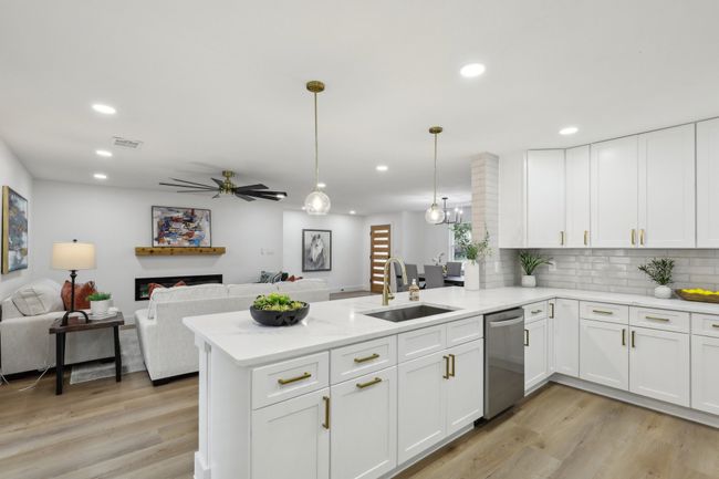 Kitchen with visible vents, a peninsula, dishwasher, a sink, and light wood-style floors | Image 7