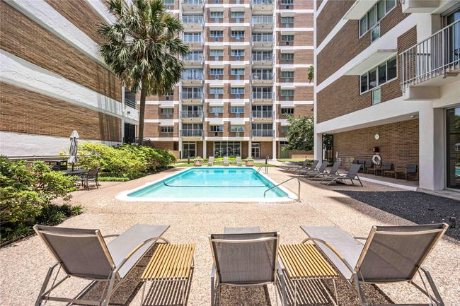 The central outdoor pool, surrounded by lounge chairs and greenery offers a relaxing communal space for residents. | Image 30