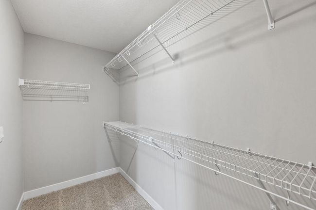 Primary bedroom with walk-in closet and private bath. Model home. Options and colors will vary. | Image 23