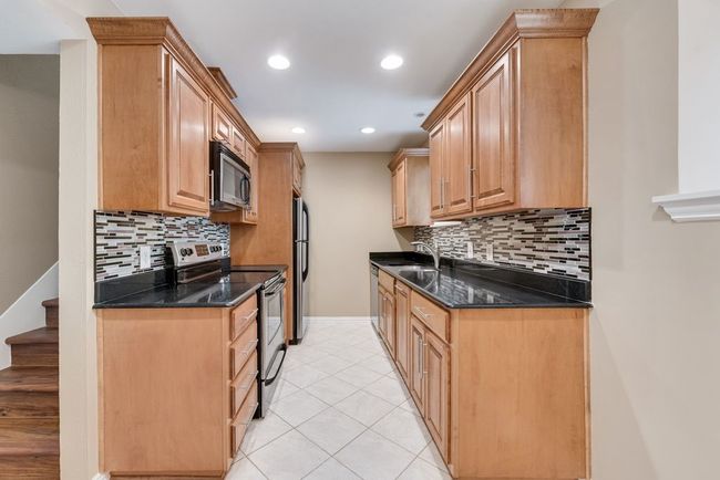 Kitchen featuring tasteful backsplash, recessed lighting, light tile patterned flooring, stainless steel appliances, and baseboards | Image 13