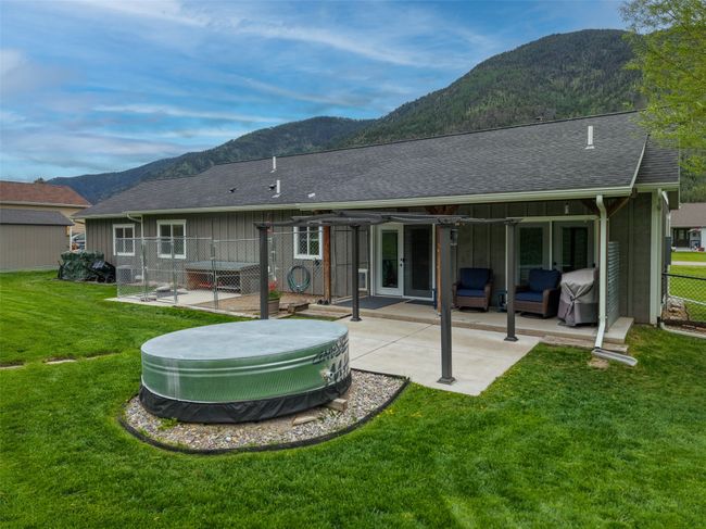 Rear view of house with a mountain view, a patio, board and batten siding, and roof with shingles | Image 42