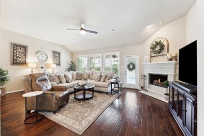 This home boasts an open concept living & kitchen with an ideal layout, a home built for entertaining! Notice the view out to the backyard oasis, ample lighting and plantation shutters. | Image 3