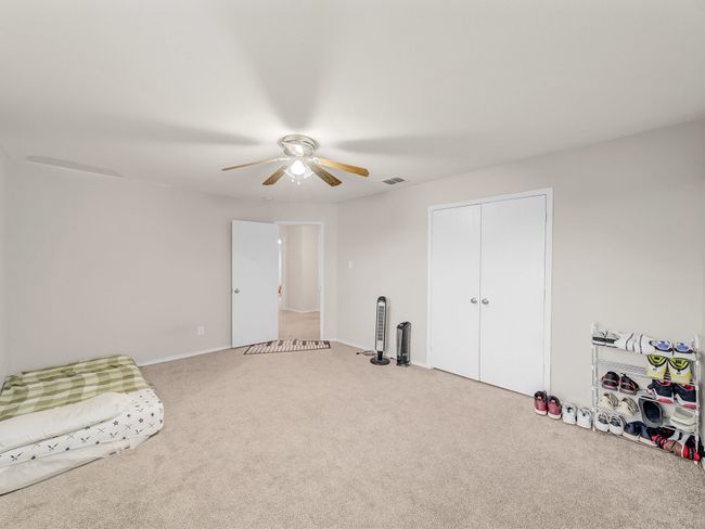 Unfurnished bedroom with carpet floors, ceiling fan, a closet, and baseboards | Image 21