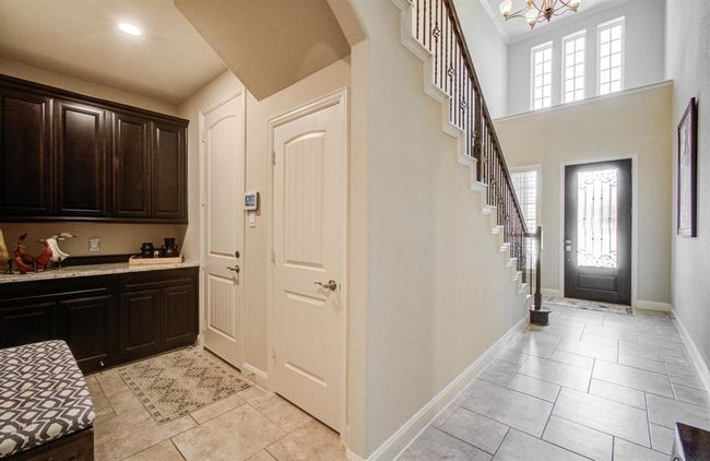Bright front foyer, mud room area with counter and cabinets. Door on far left leads to the garage, the door next to it is a closet. | Image 6