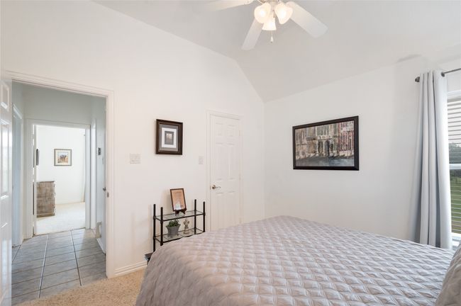 Bedroom featuring light colored carpet, lofted ceiling, ceiling fan, and light tile patterned floors | Image 27