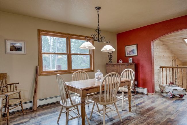 Dining area featuring wood finished floors, arched walkways, and a baseboard heating unit | Image 13