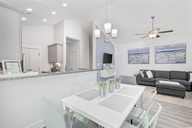 Dining room featuring recessed lighting, vaulted ceiling, visible vents, light wood-style floors, and ceiling fan with notable chandelier | Image 16
