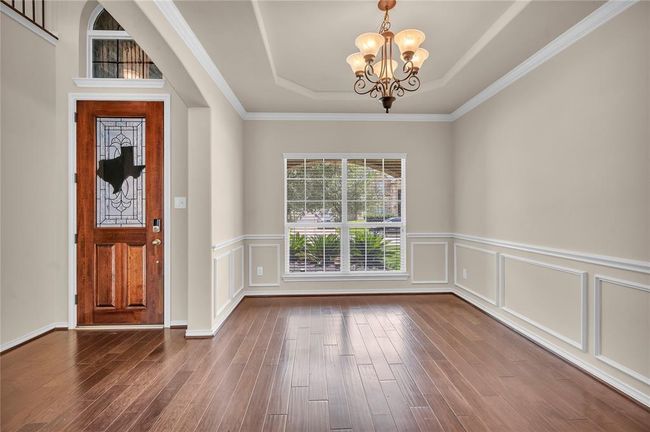 Classic formal dining room featuring a stunning tray ceiling and exquisite accent molding. | Image 6