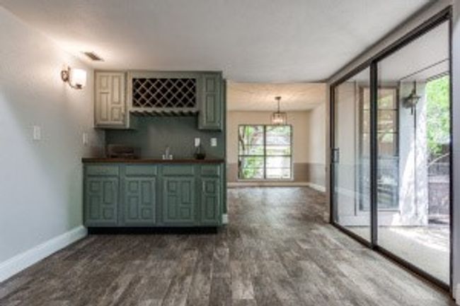 Bar featuring indoor wet bar, baseboards, and dark wood-type flooring | Image 10