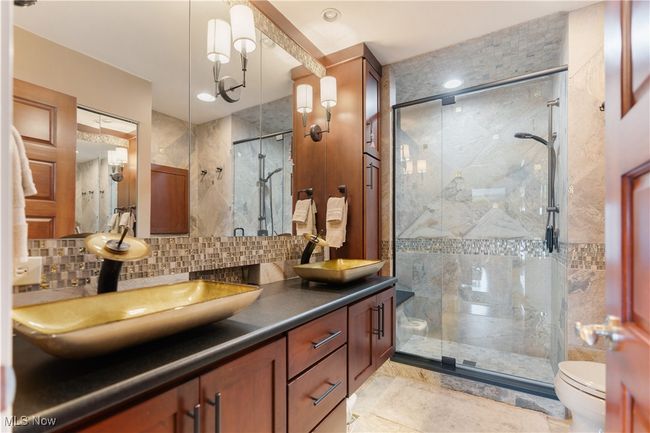 This is a new bathroom with stunning vessel bowl sinks, , tiled shower, new tiled backsplash and tiled flooring. | Image 29