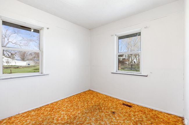 Carpeted empty room featuring a wealth of natural light, visible vents, and baseboards | Image 13