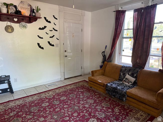 Living room with visible vents, baseboards, and light tile patterned floors | Image 5