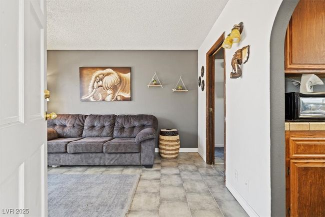 Living room with a toaster, baseboards, arched walkways, and a textured ceiling | Image 41
