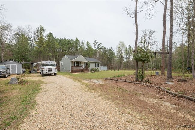 View of front of house featuring a porch, gravel driveway, an outbuilding, and a storage shed | Image 30