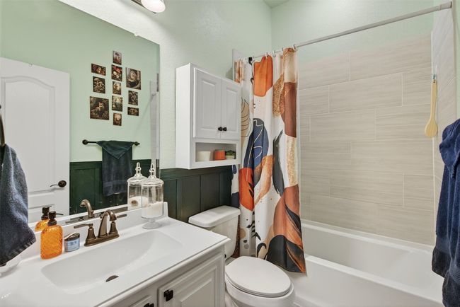 Bathroom featuring vanity, shower / bathtub combination with curtain, and wainscoting | Image 30