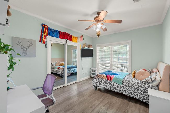 Bedroom with baseboards, crown molding, a ceiling fan, and wood finished floors | Image 20