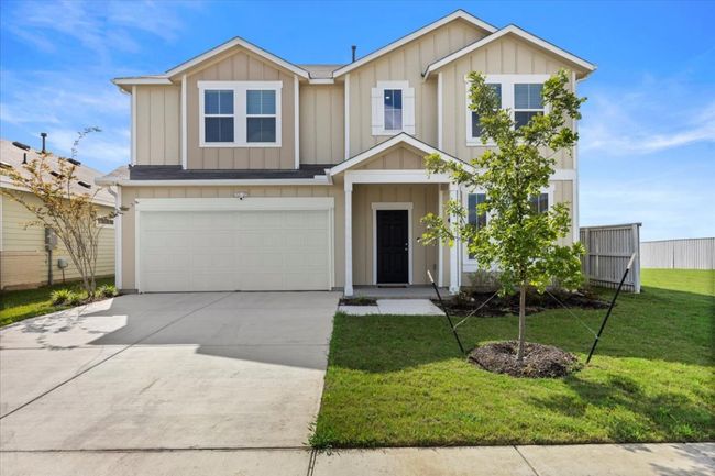 View of front of property featuring board and batten siding, an attached garage, and driveway | Image 21
