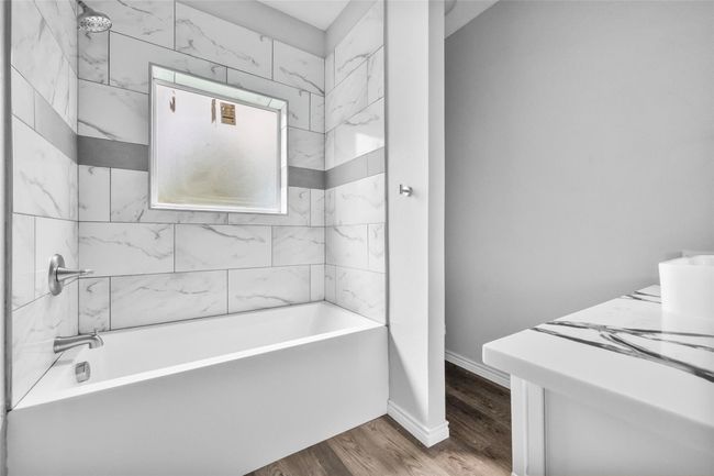 Bathroom featuring wood finished floors and shower / bathtub combination | Image 5