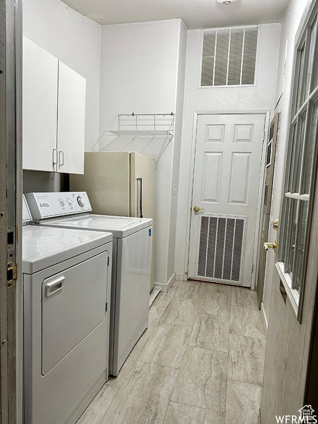 Washroom with cabinet space, washing machine and dryer, and visible vents | Image 39
