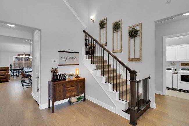 Foyer entrance featuring wood finished floors, stairway, and a high ceiling | Image 4