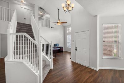 Foyer with high vaulted ceiling, ceiling fan with notable chandelier, and hardwood / wood-style floors | Image 3