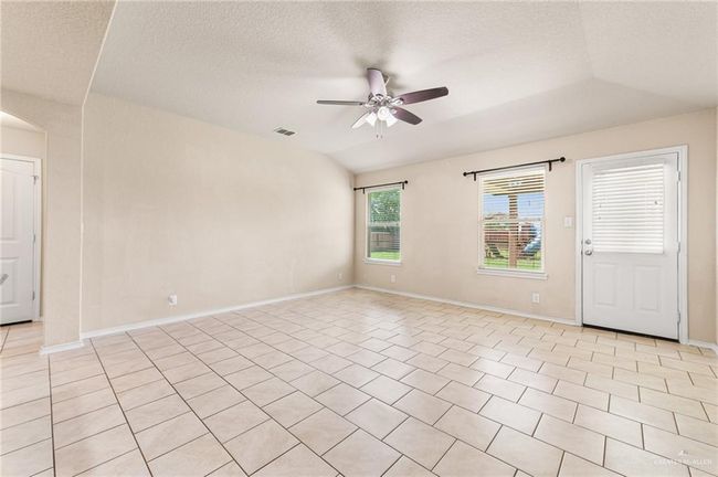 Unfurnished room with a ceiling fan, a textured ceiling, arched walkways, and light tile patterned floors | Image 8
