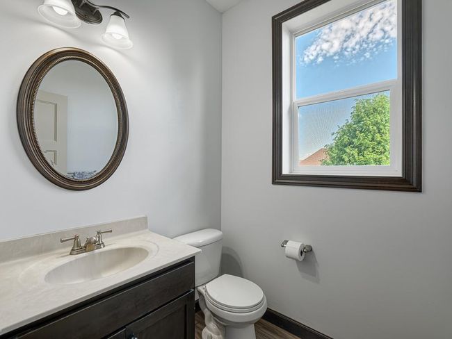 The powder room is elegantly tucked away behind the kitchen. | Image 17
