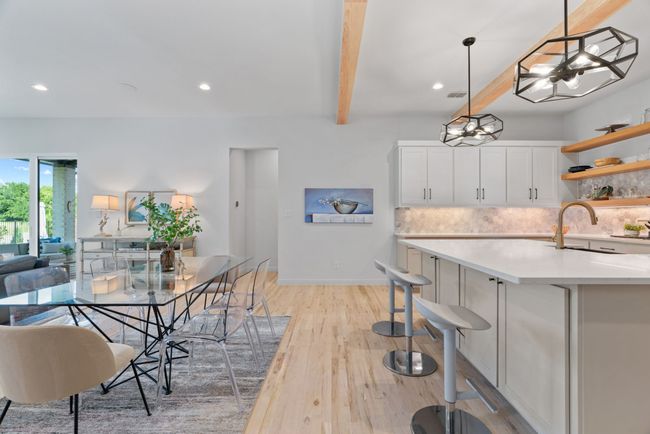 Dining room with beam ceiling, light wood-type flooring, recessed lighting, and a chandelier | Image 13