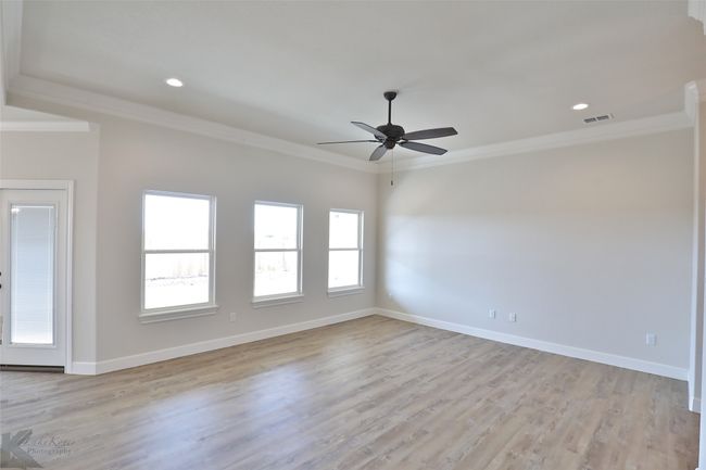 Unfurnished room with plenty of natural light, crown molding, a ceiling fan, light wood-style floors, and recessed lighting | Image 7