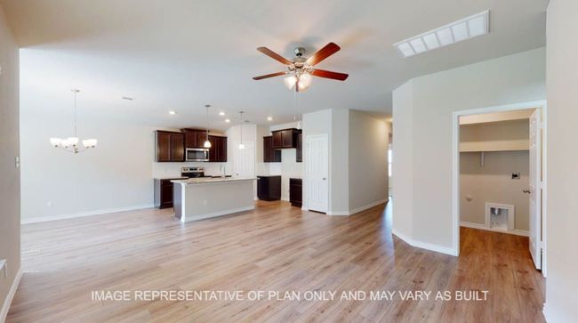 Unfurnished living room with a ceiling fan, light wood finished floors, a chandelier, a sink, and baseboards | Image 11