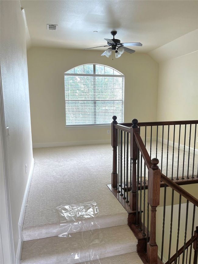 Staircase with carpet flooring, ceiling fan, and lofted ceiling | Image 12