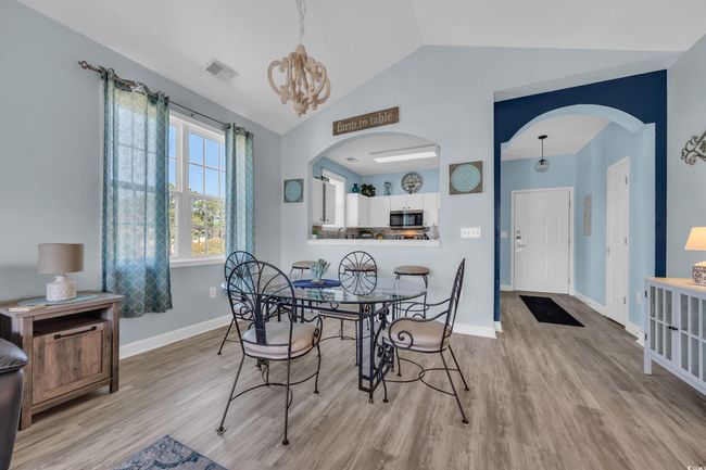 Dining space with arched walkways, wood finished floors, visible vents, and baseboards | Image 11