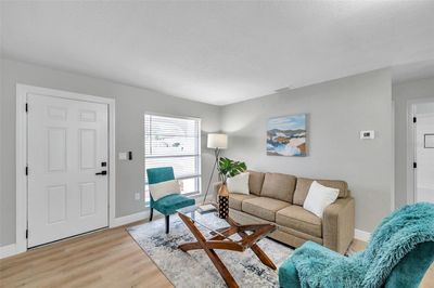 Walk through the front door and into a beautifully updated living room with contemporary charm and abundant natural light. | Image 2