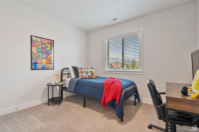 Bedroom with carpet floors and an office area | Image 19