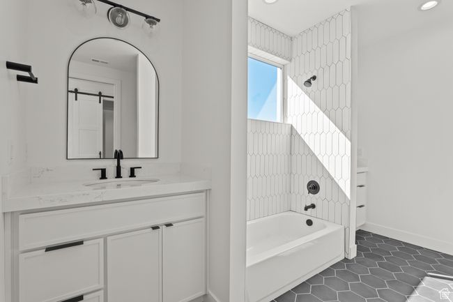 Bathroom featuring vanity, dark tile patterned floors, and bathing tub / shower combination | Image 35