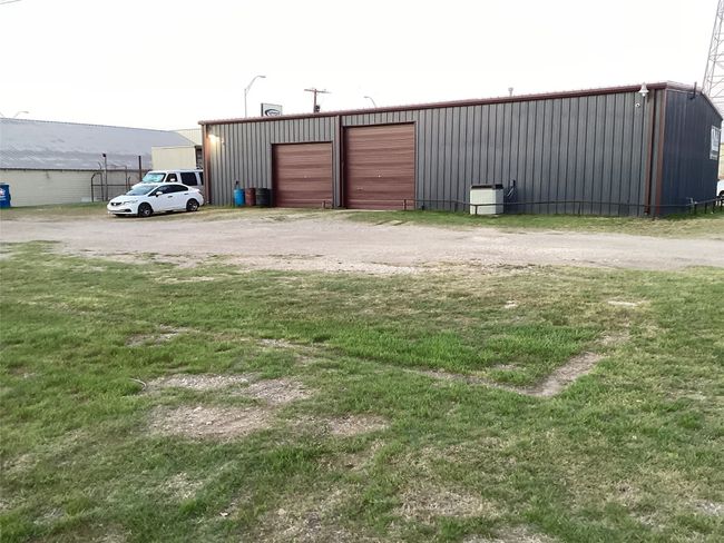 View of yard featuring an outbuilding, a detached garage, and a pole building | Image 4