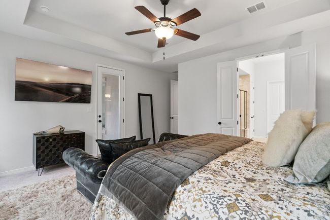 Cozy carpet flooring, private patio access, and French doors leading to the en-suite bathroom. | Image 18