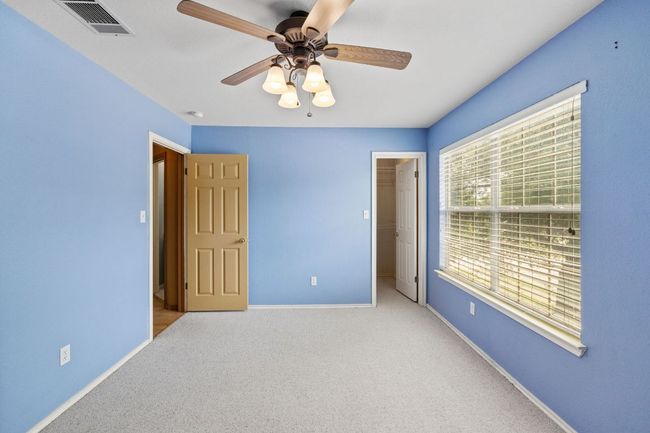 Unfurnished bedroom featuring carpet flooring, a walk in closet, and a ceiling fan | Image 21