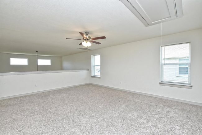 Empty room featuring attic access, carpet floors, baseboards, and a ceiling fan | Image 14