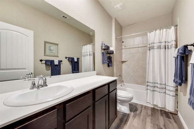 Bathroom featuring vanity, wood finished floors, and shower / tub combo with curtain | Image 19