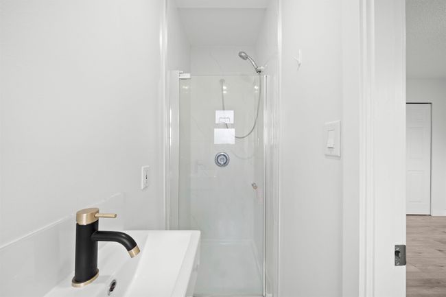 Bathroom with wood finished floors, a sink, and a shower stall | Image 13