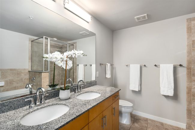 Bathroom with double vanity, tiled shower, tile patterned floors, and a tub to relax in | Image 11